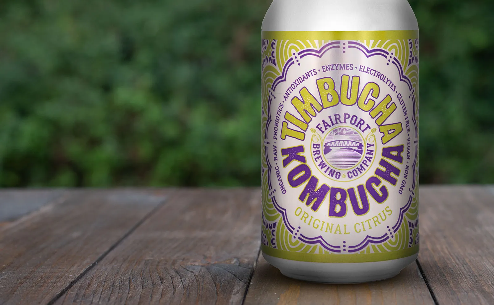 A can of Timbucha Original Citrus on a wooden table in front of green trees