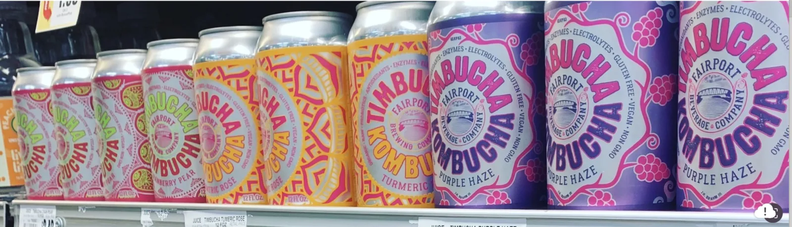 Timbucha Kombucha cans on a store shelf — Cranberry Pear, Turmeric Rose and Purple Haze